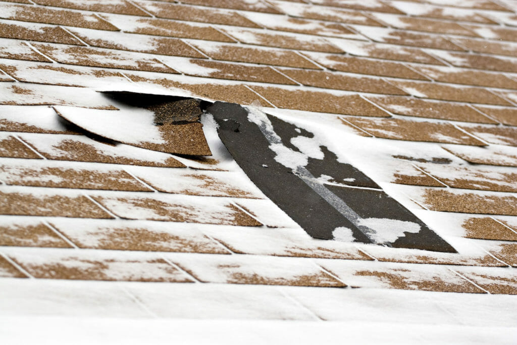 snow on damaged roof